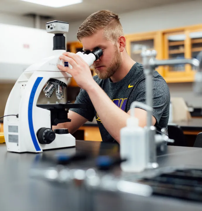 Student looking through microscope
