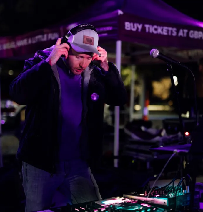 Ian Goldsmith on UNI campus, putting on headphones to DJ