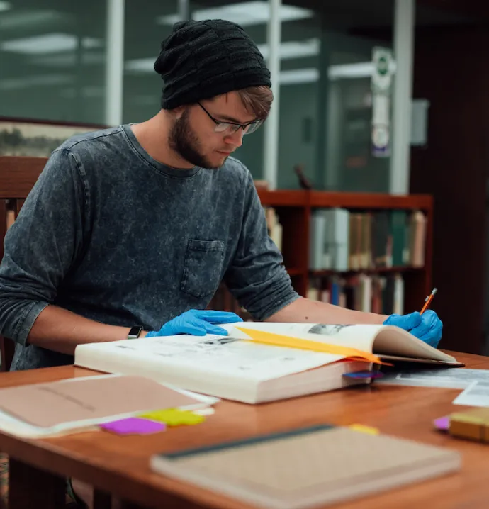 Student looking through old book and making notes