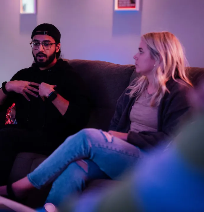 Man talking on a couch next to a woman