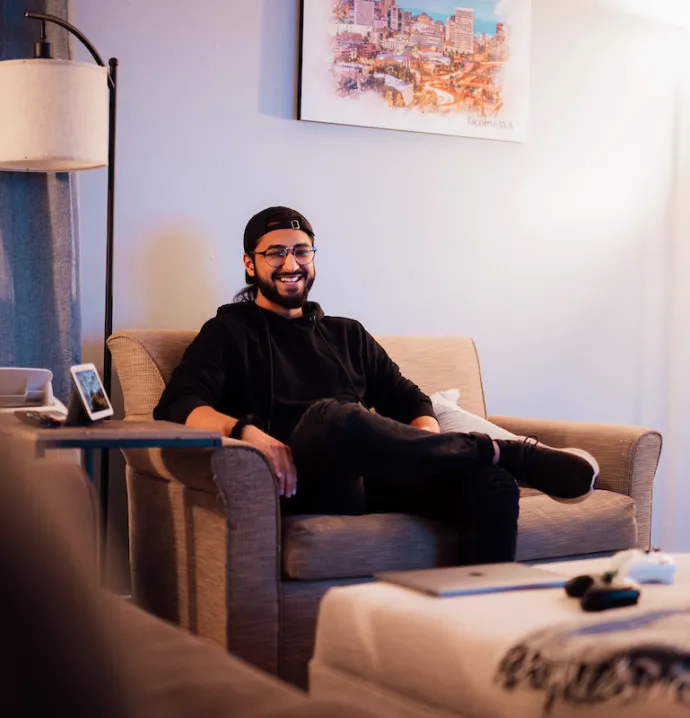 Umar Chohan sitting in armchair, smiling