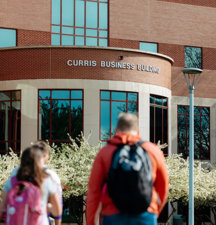Students walking toward Curris Business Building