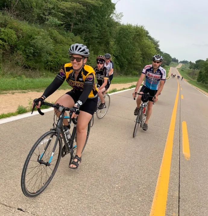 Bikers on RAGBRAI including one woman wearing a UNI jersey