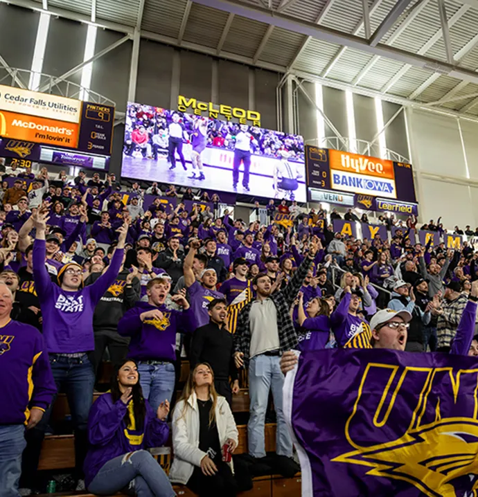 Fans in the stands cheer for the UNI wrestling team.