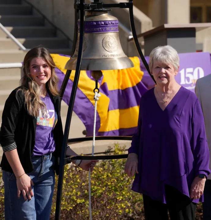 Ali Webster, Noreen Hermansen, and President Mark Nook with Sesquicentennial Bell