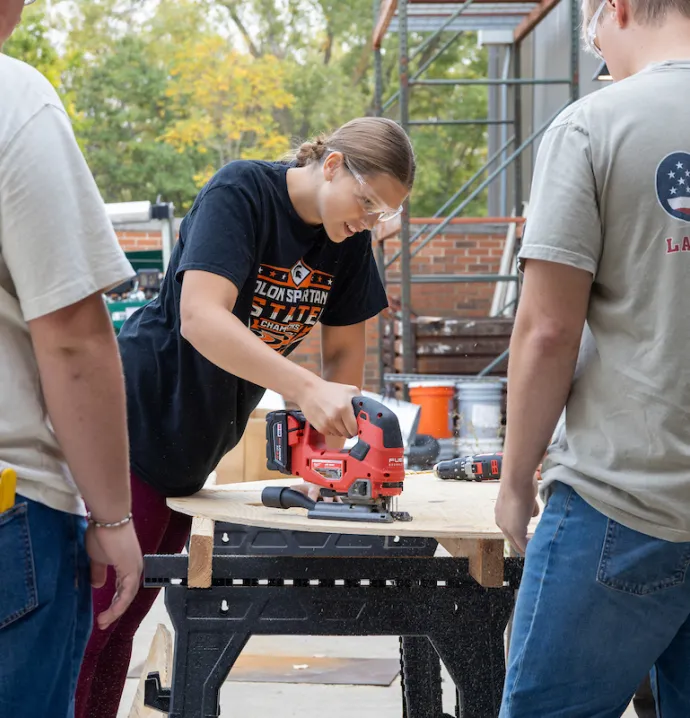 Students saw wood for UNI Homecoming float