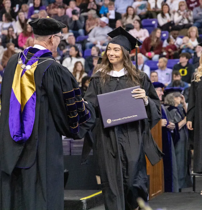 Graduate walks across the stage at UNI Commencement