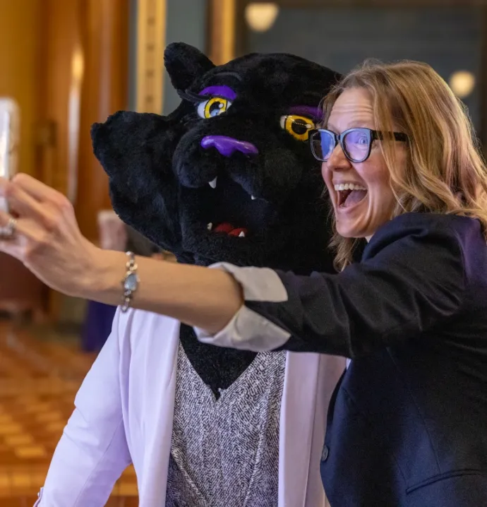 Woman takes a selfie with TK the mascot at the Iowa Capitol