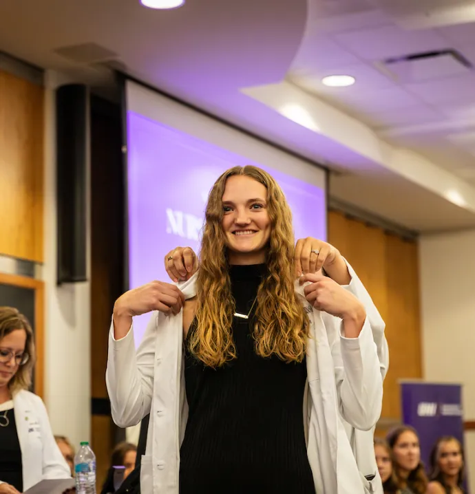 Nursing student puts on white coat