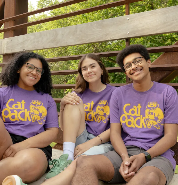 Students on bridge wearing Cat Pack t-shirts