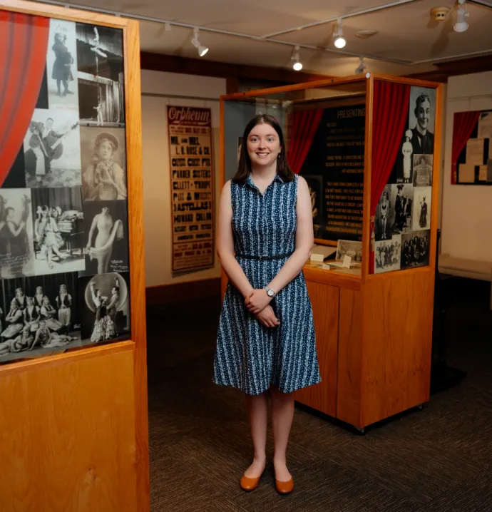 UNI alum standing next to history exhibit