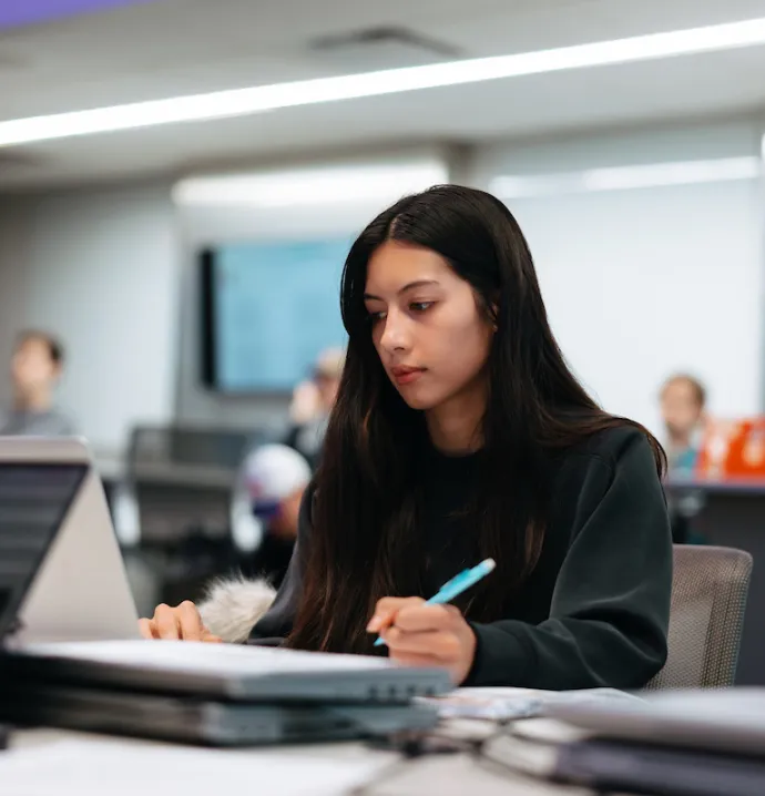 Business student writing at desk