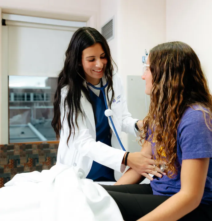 Nursing student working with patient