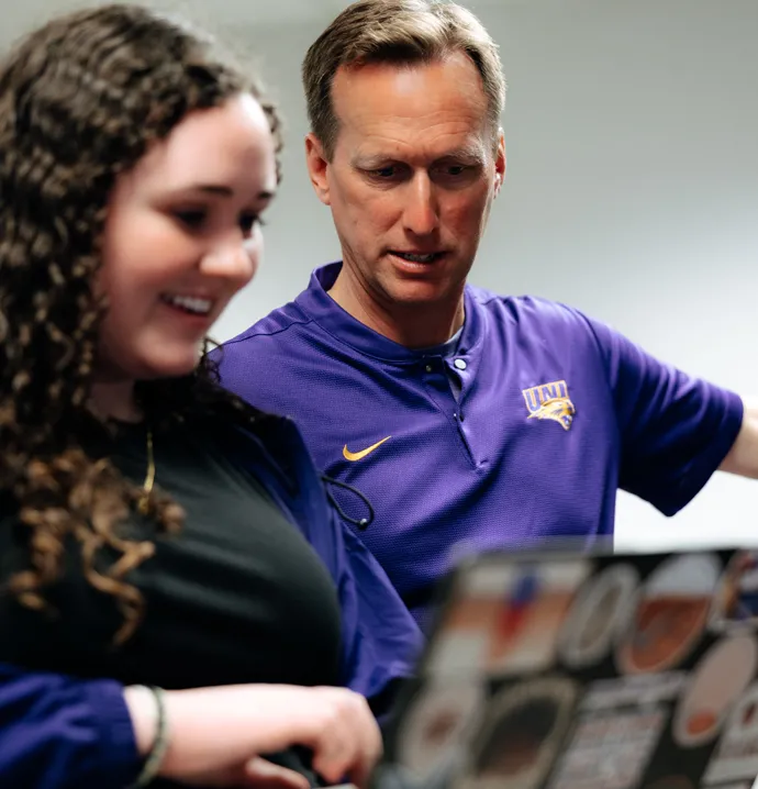 Student works with professor on computer. 