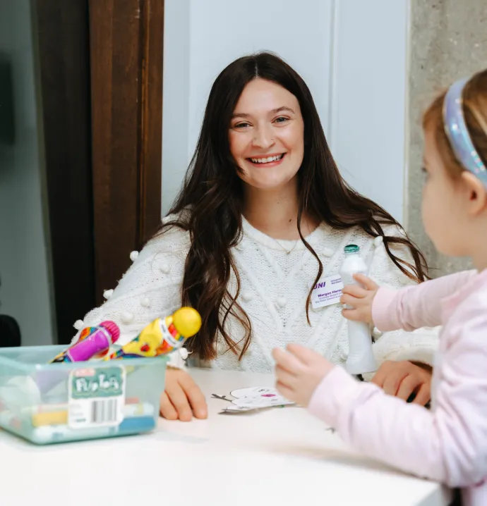 Speech-language pathology student working with young client