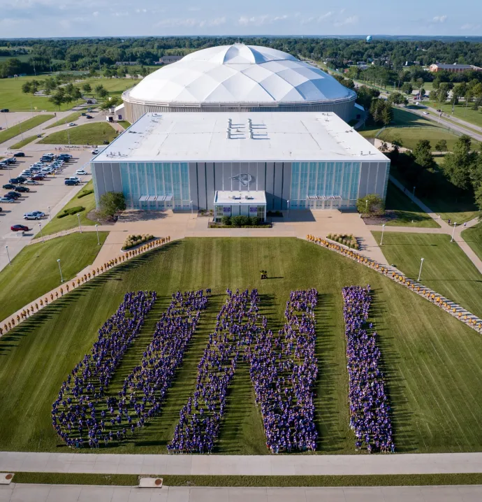 Incoming UNI students pose in the shape of the U-N-I letters in front of the McLeod Center