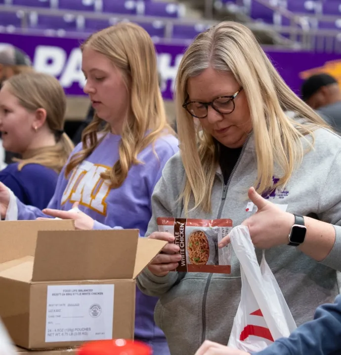 Pack the Dome volunteers packing food into bags