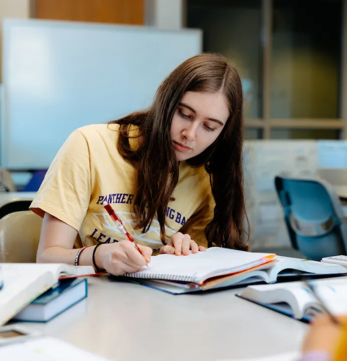 Student taking notes in textbook