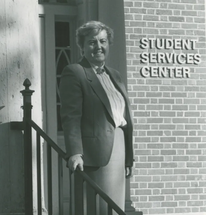 Sue Follon standing in front of Student Services Center sign on UNI campus