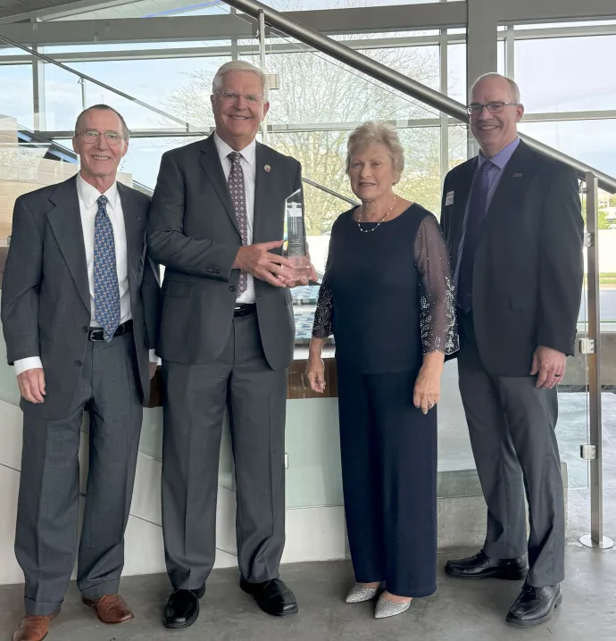 Tom Nordstrom  holding his award, alongside his wife, Art Cox and Brett Olsen