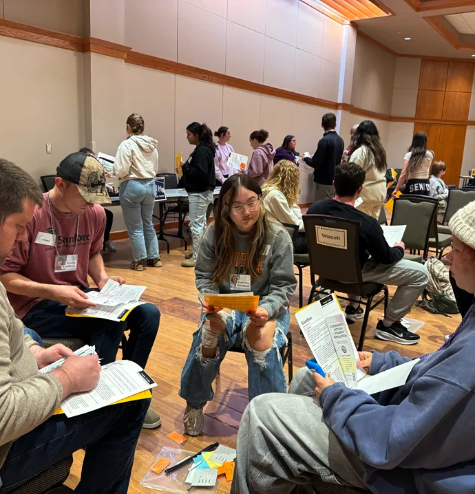 Students gather in families as they participate in the poverty simulation.