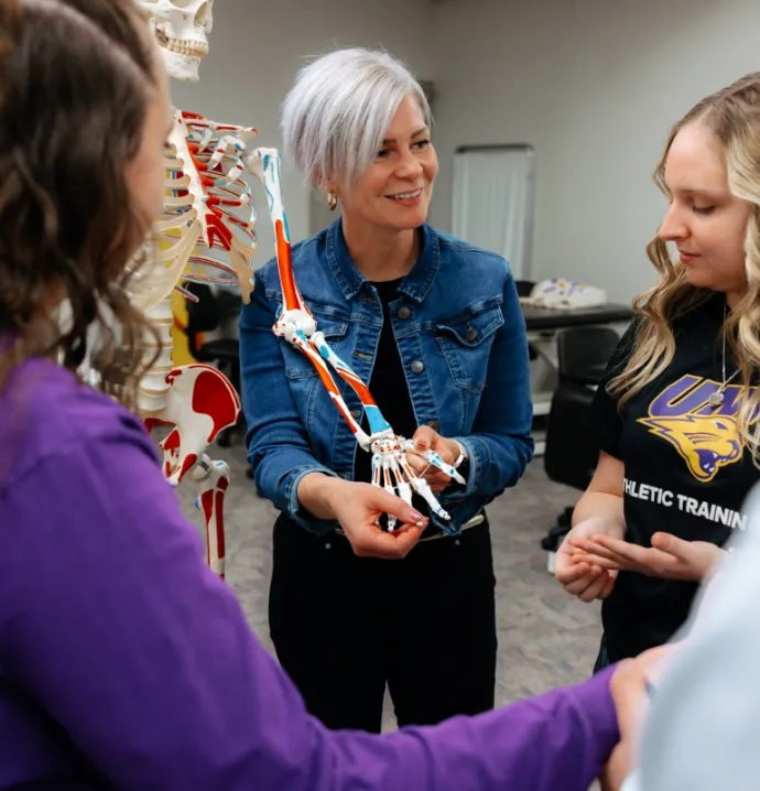 Kelli Snyder showing students an artificial skeleton
