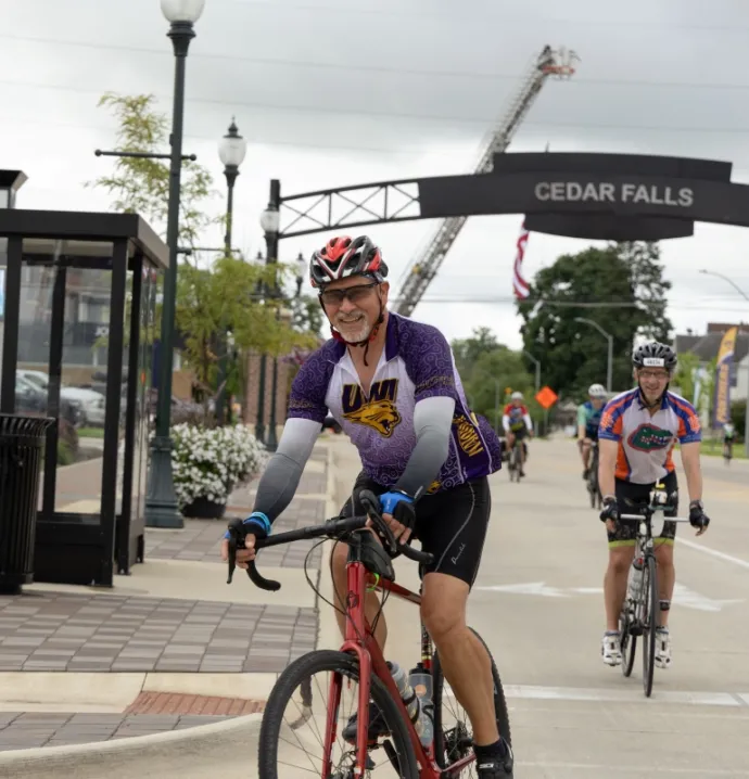 RAGBRAI rider wearing UNI jersey entering Cedar Falls downtown district