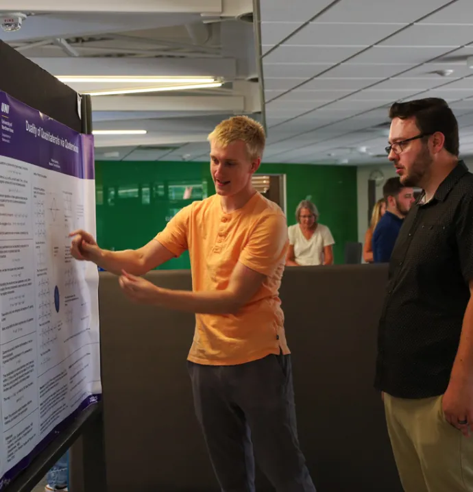 A UNI student talks through his research at the Summer Undergraduate Research Program Symposium