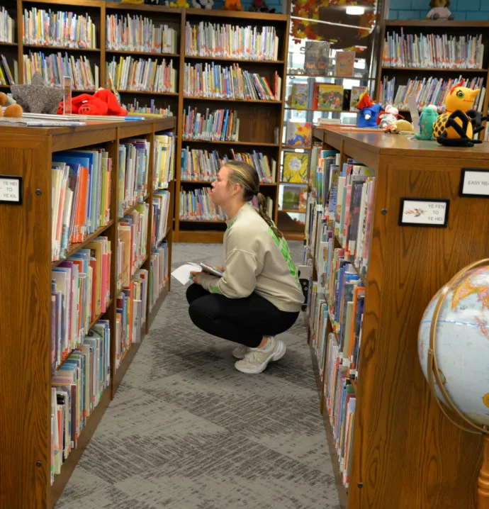 Student looking for a book in the TEACH Studio