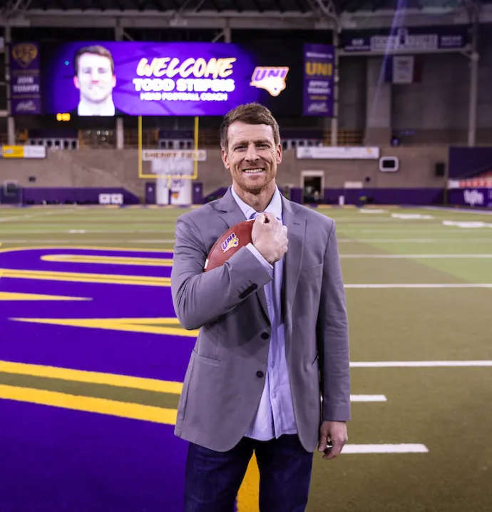 Todd Stepsis in UNI-Dome holding football