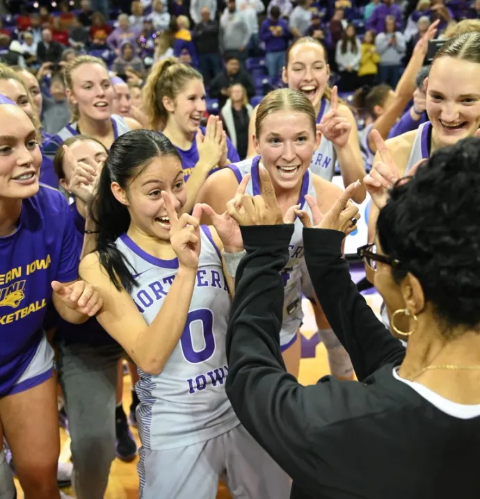 The UNI women&#039;s basketball team celebrating with head coach Tanya Warren