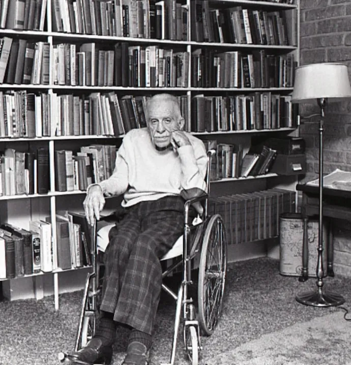 James Hearst posing in front of bookcase. 
