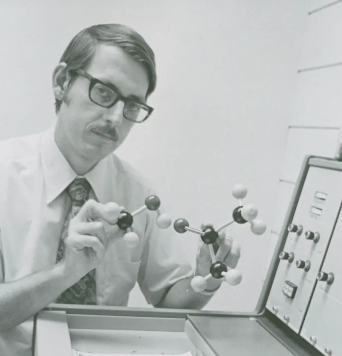 Summer 1974: Paul Rider manipulating a chemistry molecular model in front of a machine.