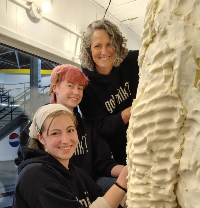 Sarah Pratt and twin daughters sculpting butter. 