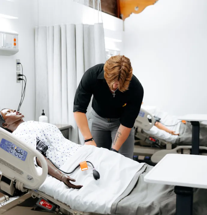 Nursing student checking on manikin