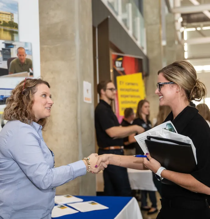 Student shaking hands with prospective employer at UNI career fair
