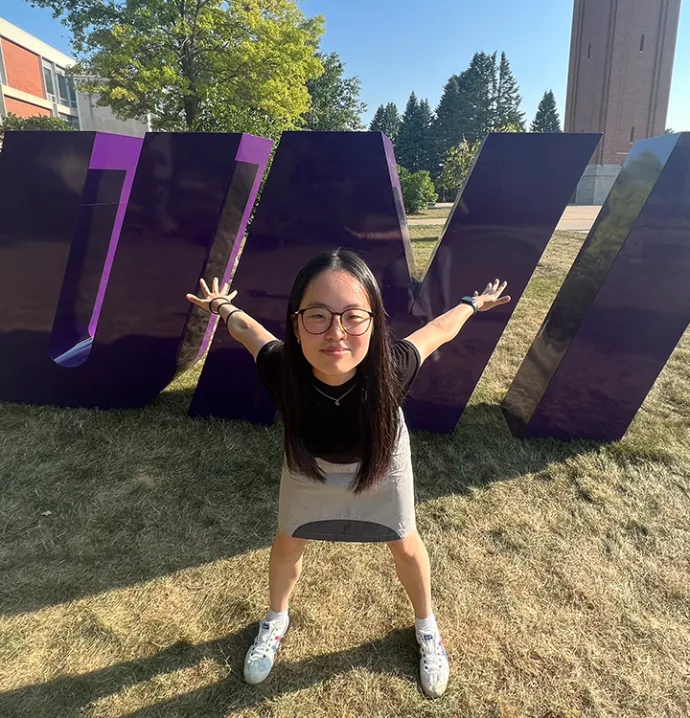 Yanting Wang standing in front of UNI sign