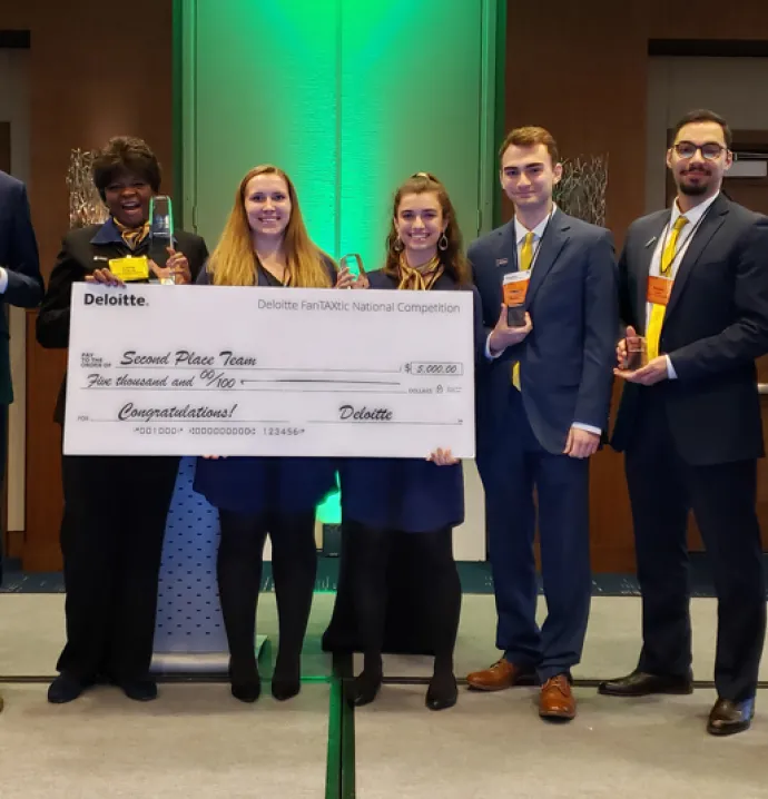 University of Northern Iowa Accounting students pose with winning check and trophy at Deloitte FanTAXtic national competition