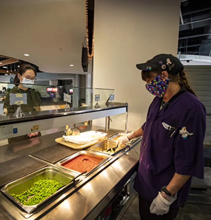 UNI cooks serve food to students remaining on campus during COVID-19.