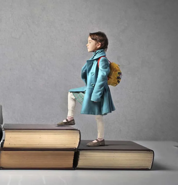 A child stepping on giant books