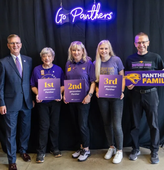 Fowler family posing with President Nook with first, second and third generation Panther signs