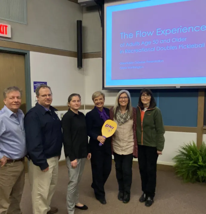 Glynis Worthington with pickleball paddle at dissertation defense