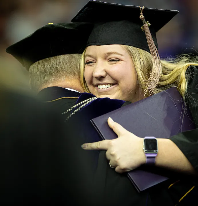 UNI graduate hugging President Nook at Commencement