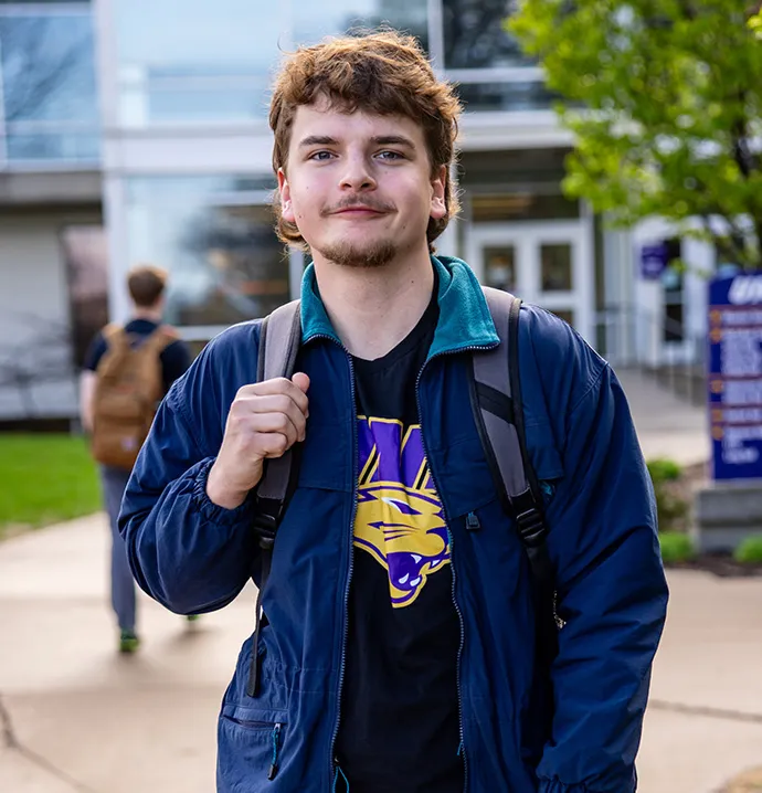 Real estate student standing with hand on backpack