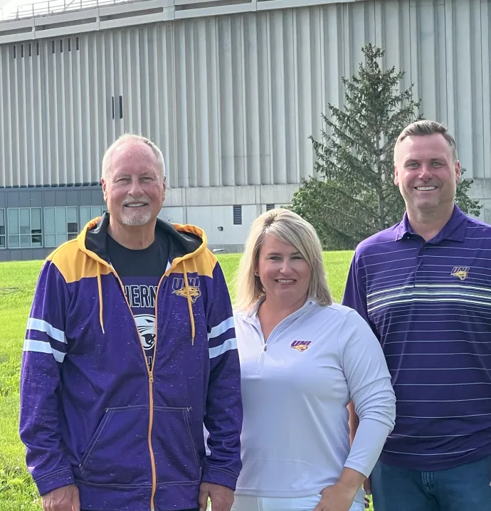 Stan Poe, Katy Harbaugh, and Andy Poe in front of the UNI-Dome