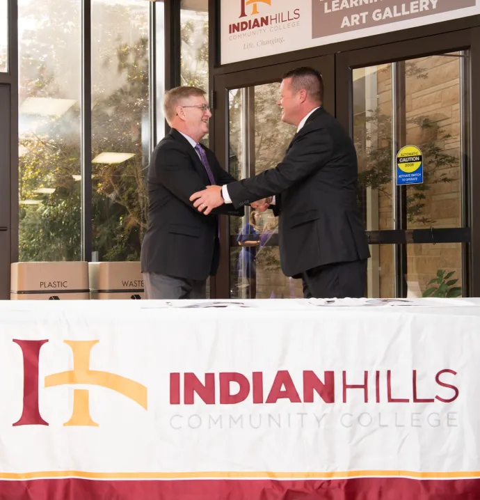 UNI President Mark Nook and Indian Hills President Matt Thompson shaking hands