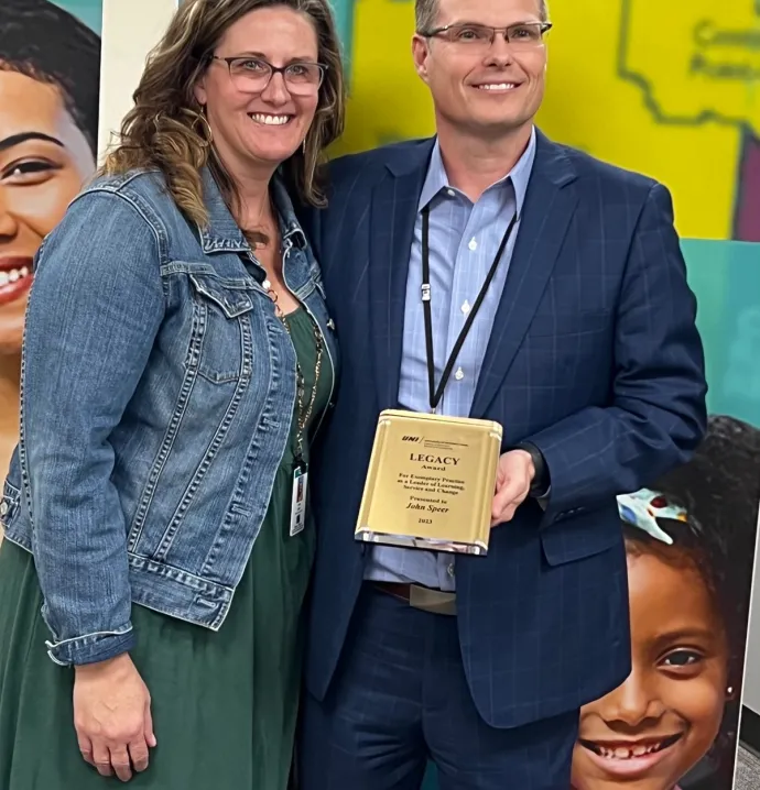 John Speer holding Educational Leadership Legacy Award with wife
