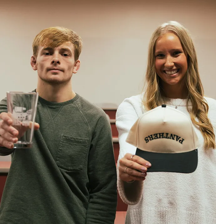 Marketing students hold up the prodcuts they created