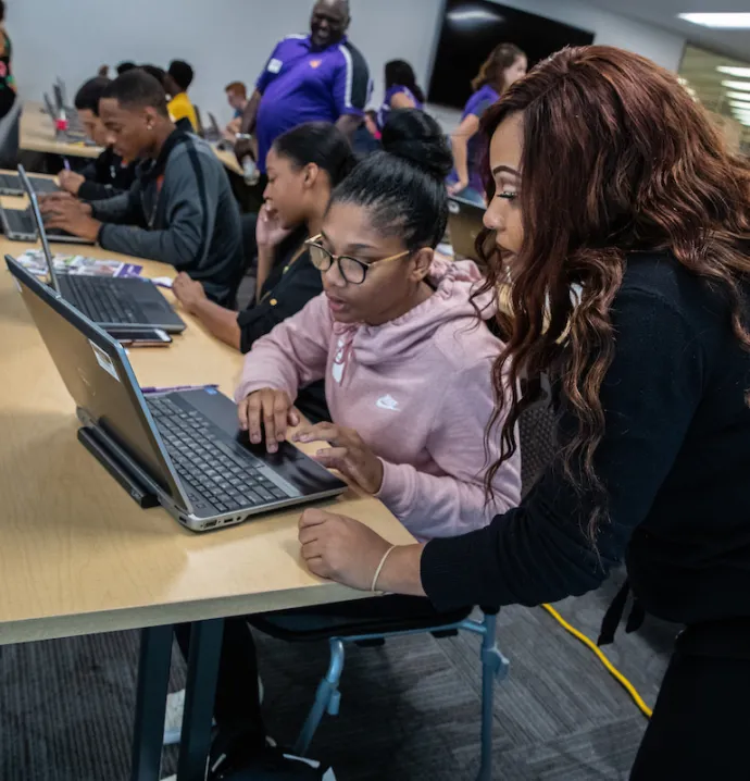 An educator works with a high school student