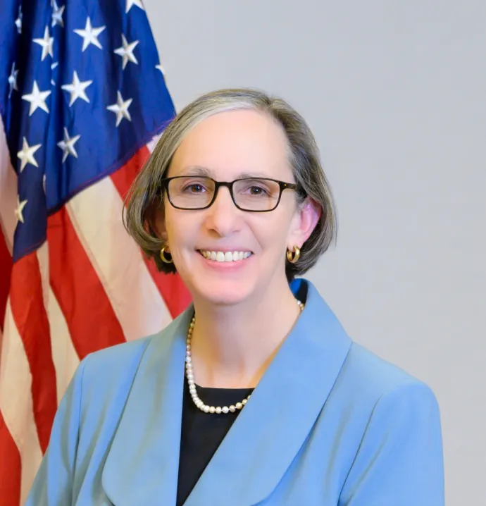 Kimryn Rathmell in front of an American flag